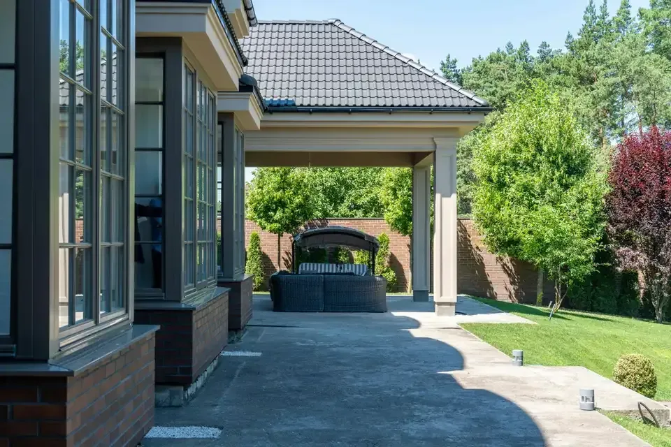 Covered concrete patio overlooking a landscaped backyard