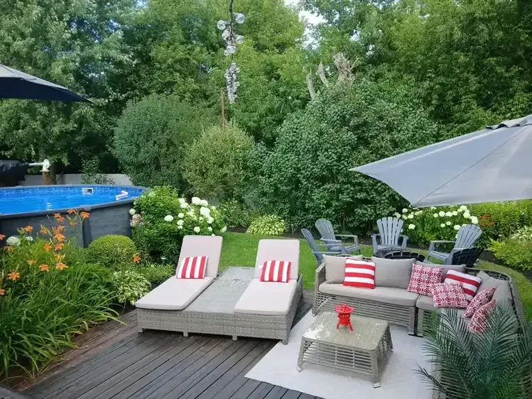 Backyard deck lounge beside a pool and garden