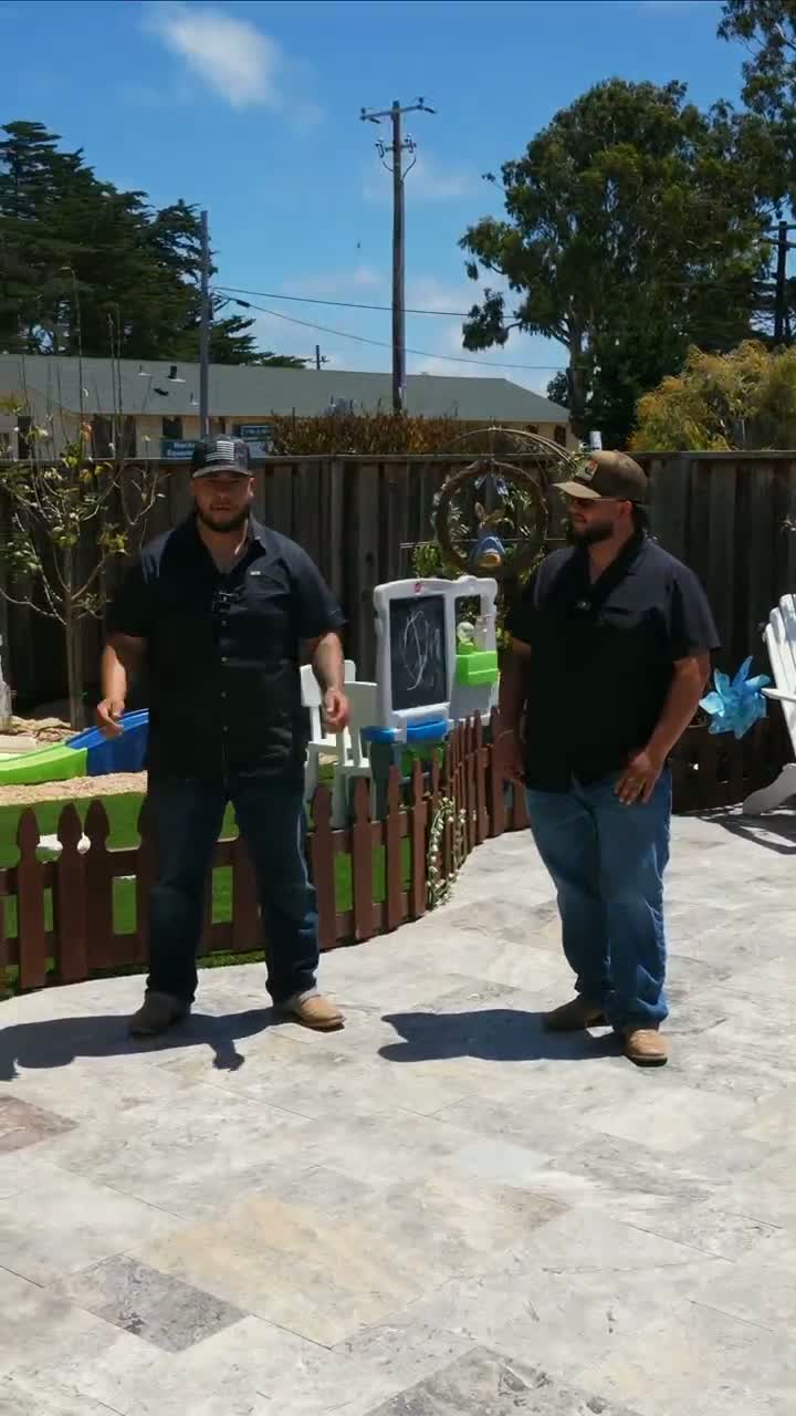 Armando and Jesus Garcia standing on a finished paver patio they installed